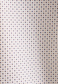 Tissu léger avec un motif en grille de petits carrés marron et beige sur un fond blanc. La texture semble lisse et douce.