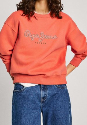 Coral sweatshirt with ribbed cuffs and neckline, featuring a grey embroidered logo reading "Pepe Jeans London." Paired with blue denim jeans.