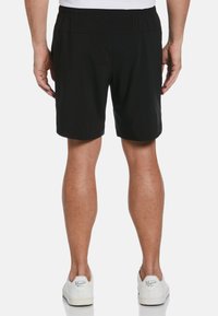 Zwarte sportshorts met een elastische tailleband, lichtgewicht stof en zijzakken. Draagt samen met witte sneakers.
