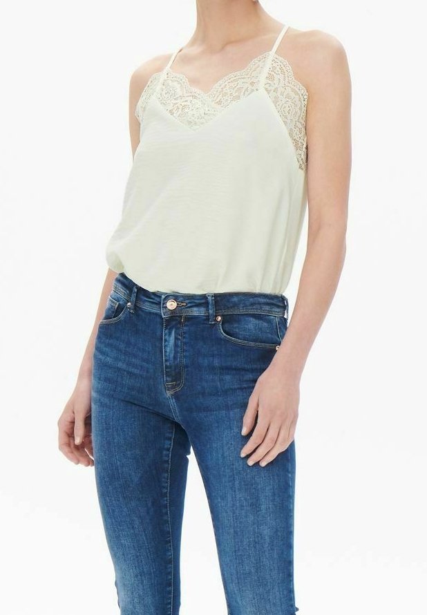 Canotta verde chiaro con dettagli in pizzo sullo scollo, abbinata a jeans skinny blu scuro. Presenta spalline sottili e una vestibilità rilassata.