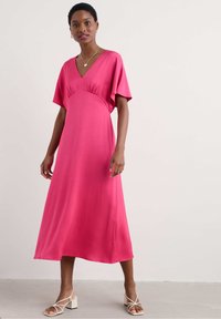Rochie midi roz cu decolteu în V, mâneci scurte tip batwing și detaliu cu umplere la talie. Țesătură netedă și siluetă fluidă.