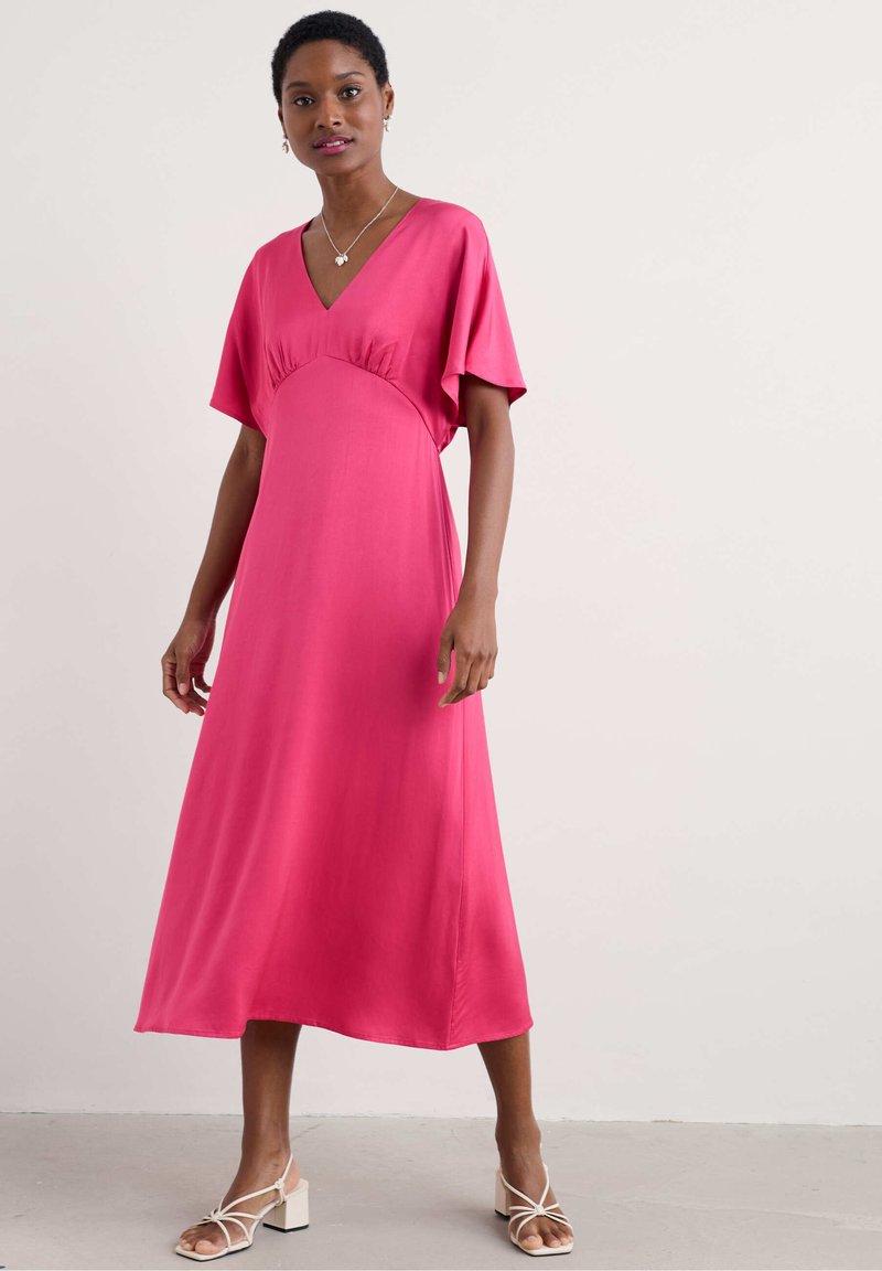 Rochie midi roz cu decolteu în V, mâneci scurte tip batwing și detaliu cu umplere la talie. Țesătură netedă și siluetă fluidă.