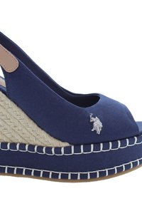 Námořnické modré plátěné wedge sandály s otevřenou špičkou a remínkem přes patu. Mají tkanou jutu jako podrážku, bílé stehy a malý detail stříbrného loga.