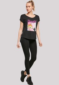 Svart t-skjorte med Bambi-grafikk, rund hals, korte ermer, sammen med svarte leggings og svarte treningssko.