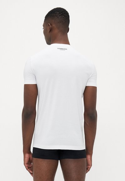Weißes T-Shirt mit kurzen Ärmeln und rundem Ausschnitt, aus glattem Stoff gefertigt, mit einem kleinen Logo auf der Rückseite nahe dem Kragen.