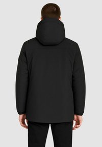Giacca imbottita nera con un ampio cappuccio rotondo. Il design presenta un taglio dritto, polsini elasticizzati e una texture liscia senza motivi visibili.