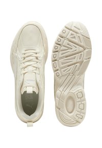 Cremfarbene Sportschuhe mit einem strukturierten Leder-Obermaterial, gepolsterter Zunge und einer gummierten Sohle mit Muster für besseren Halt.