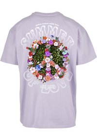 Lavender cotton t-shirt featuring a colorful floral peace sign graphic on the back, with “peace comes with love” and “love comes with peace” text.