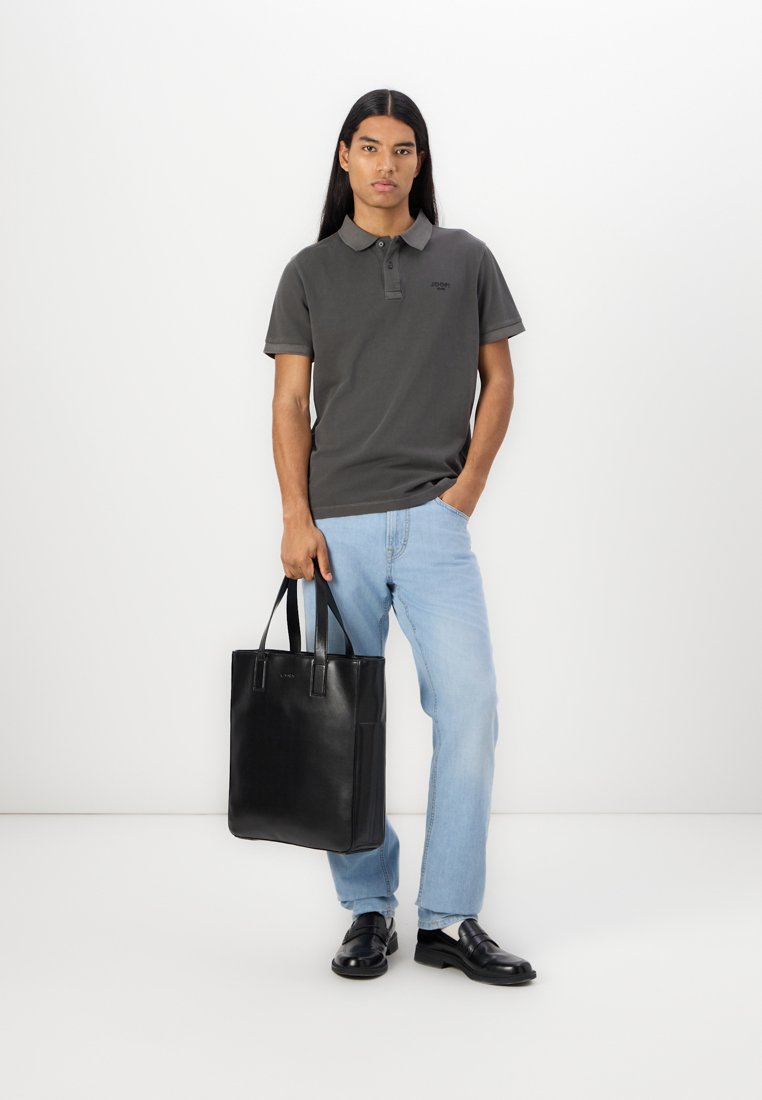 Polo en coton gris foncé avec un col et trois boutons, associé à un jean en denim bleu clair et un sac fourre-tout en cuir noir.