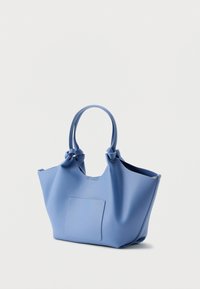 Modrá kožená taška cez rameno s textúrovaným povrchom, dvoma uzlovými rukoväťami a predným náprsným vreckom. Otvorený horný dizajn, široký tvar tela.