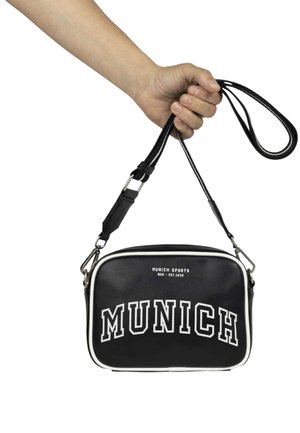 Čierna crossbody taška s bielym lemovaním, s nápisom "MUNICH" v tučných písmenách. Viditeľný nastaviteľný popruh a kovové detaily.