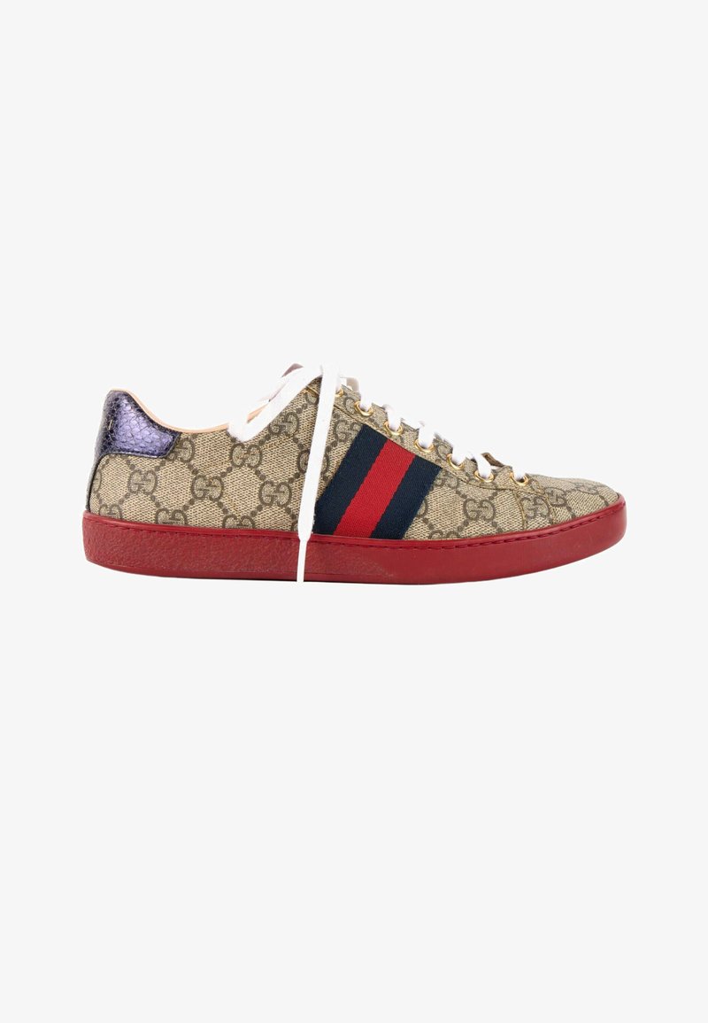 Baskets basses avec motif monogramme GG beige, bande latérale rouge et bleue, semelle rouge, lacets blancs et languette de talon métallique violette.