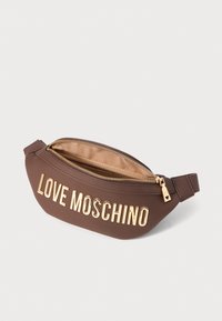 Prune Love Moschino vöö kott kuldse tõmblukuga ja suurte kuldsete tähtedega ees, beež vooder on nähtav avatud tõmbluku kaudu.