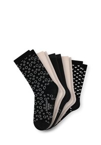 Ensemble de sept paires de chaussettes dans des nuances de noir et de nude, présentant des motifs de cercles et de cœurs. Le matériau semble doux avec une texture lisse.