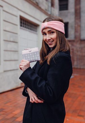 Zippered wallet in gray with pink accents and bunny patterns. Soft pink headband, black coat, and wood floor background.