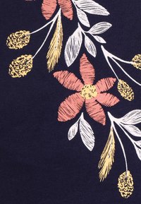 Marinblått tyg med ett blommönster som har rosa och gula blommor, gröna blad och texturerade gula accenter.