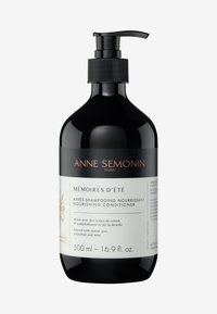 Black plastic bottle with a pump, featuring a white label. Text includes "MÉMOIRES D’ÉTÉ" and details about the nourishing conditioner.