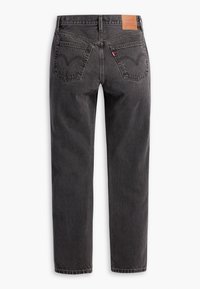 Jeans de mezclilla negra con cintura alta y corte recto. Presenta dos bolsillos traseros con costuras sutiles y una etiqueta de marca de cuero marrón en la cintura.