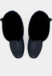 Bottes de pluie en caoutchouc navy avec une large ouverture et un haut texturé, dotées d'un embout moulé et d'une sangle à l'arrière pour un enfilage facile.