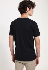 Black, short-sleeved T-shirt with a round neck; soft, smooth fabric; fitted style; plain without graphics or patterns.