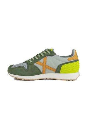 Zapatillas verdes y grises con materiales de ante y malla. Presenta detalles en naranja y un talón amarillo brillante. Suela de goma y diseño con cordones.