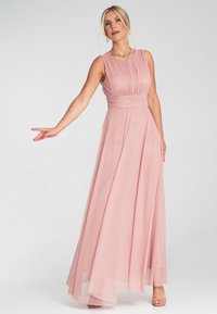 Rosa ärmelloses Maxikleid mit gerafftem Oberteil, fließendem Rock und durchscheinendem Saum. Subtile Texturen verleihen dem Material einen besonderen Akzent.