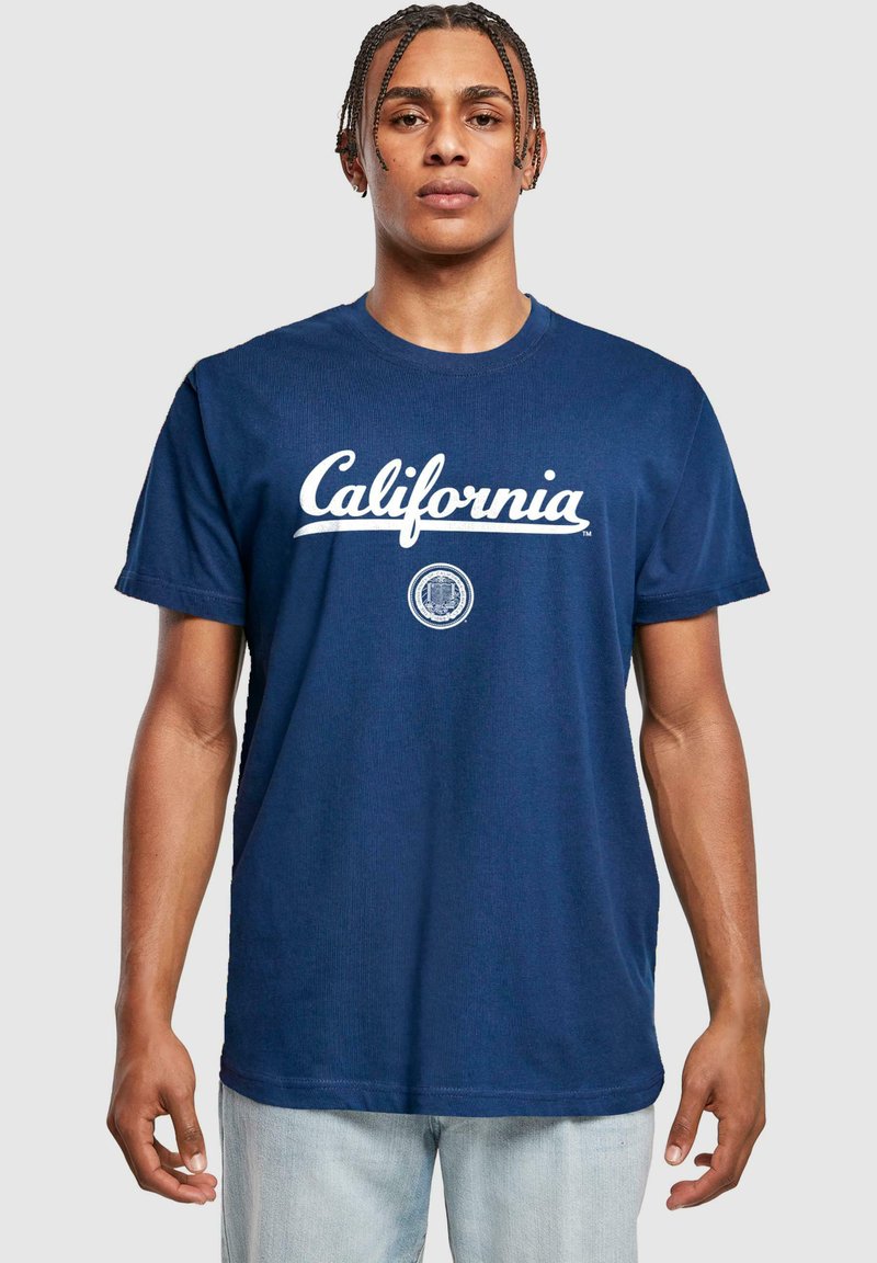 Námorně modré bavlněné tričko s bílým nápisem "California" a kulatým emblémem. Krátké rukávy, kulatý výstřih, volný střih.