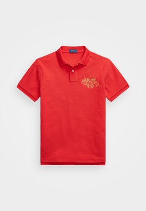 Rød bomullspolo med korte ermer, med et gult brodert design av to ryttere på venstre brystområde og en klassisk krage.