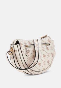 Lille hvid halvmåneformet crossbody taske med beige blomster mønster, front lynlås lomme og justerbar skulderrem med guldfarvet hardware.