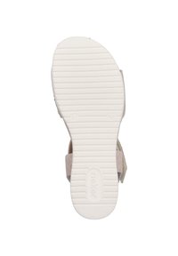 Light beige sandal with a textured white rubber sole, two adjustable straps, and a soft suede finish. Flat design for comfort.