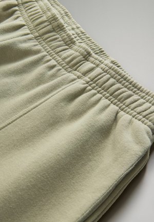 Lichtgroene sweatpants met een elastische tailleband, getextureerde stof en zichtbare stiksels langs de naden.