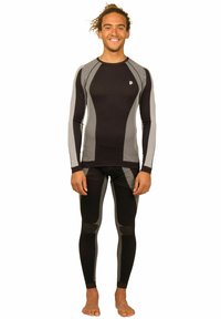 Schwarz-graues Langarm-Thermaloberteil und eng anliegende Leggings mit strukturierten Einsätzen, Rundhalsausschnitt und verstärkten Knieflicken.