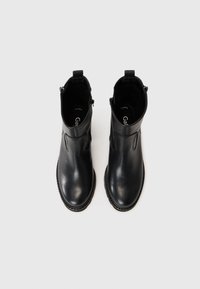 Botines de cuero negro con un acabado suave, que cuentan con una cremallera lateral, punta redondeada y una suela de goma robusta. Diseño minimalista sin adornos.