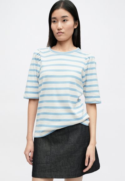 Ανθρακί και κρέμα ριγέ τοπ κοντό μανίκι με ριπ υφή και μαζεμένο σχέδιο στον ώμο, συνδυασμένο με σκούρα τζιν φούστα.