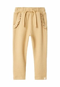 Jogging en mélange de coton dans une teinte jaune clair avec texture gaufrée, poches froncées, taille élastique et cordon de serrage.