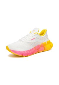 Fehér sportcipő sárga kiegészítőkkel és rózsaszín gradiens talppal. Texturált hálós felsőrésze van és kontrasztos fűzőkkel rendelkezik. Reebok logó látható.
