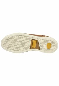 Chaussure en cuir brun avec une semelle en caoutchouc texturé. Présente un motif de grip en zigzag et un accent jaune sur le talon avec le logo de la marque.