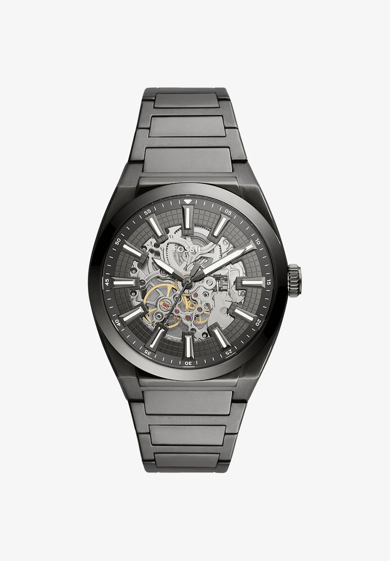 Montre-bracelet Fossil en métal noir avec cadran squelette montrant les engrenages internes, index argentés pour les heures, ainsi que les aiguilles des minutes, heures et secondes.