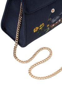 Bolso de ante azul marino con bordado floral y correa de cadena dorada. Presenta una forma estructurada y cierre de solapa.