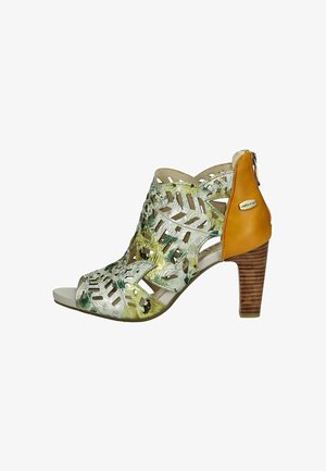 Des sandales à talons ouverts présentent un motif floral découpé en vert et jaune, des brides en cuir beige et un talon marron texturé.