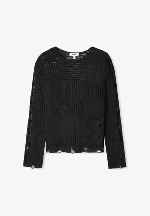 Pull en maille noire à manches longues, présentant des motifs variés, une texture à tissage ouvert et des détails effilochés au niveau de l'ourlet et des manches.