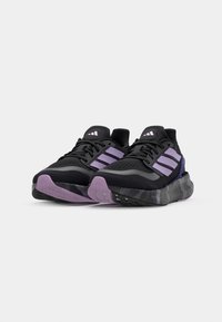 Chaussures de sport noires avec accents violets. Tige en mesh respirant, semelle coussinée avec semelle extérieure en caoutchouc noir et violet texturée, et logo à trois bandes.