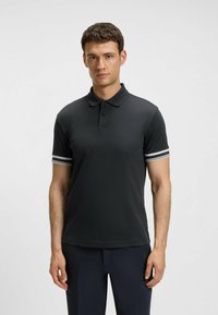 Svart polo skjorta med knappslå, korta ärmar med vita ränder, sl�ät tygkvalitet och en klassisk kragsdesign.