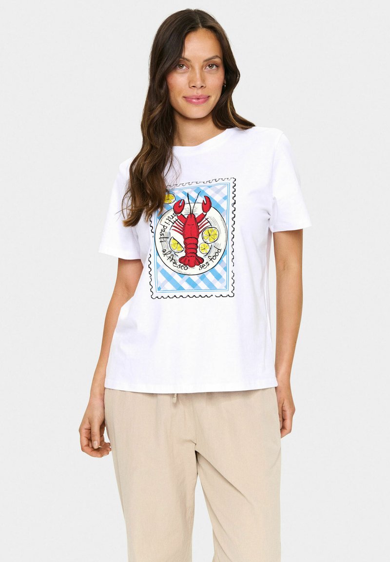 T-shirt en coton blanc avec un graphique de homard coloré au centre, entouré d'un motif à carreaux bleus et d'accents textuels circulaires.