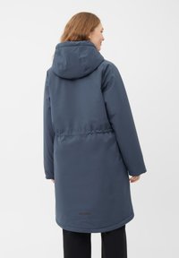 Mørkeblå vandtæt parka med hætte, indsnævret talje og lange ærmer. Glat tekstur med en rundet kant og minimale sorte detaljer.