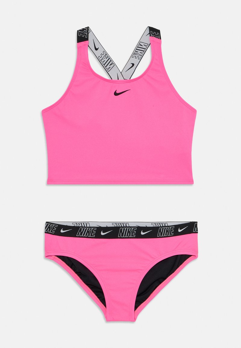 Rosa sports-bh med kryssede stropper og svart Nike-logo; matchende rosa bikini-bunn med svart livvidde som har Nike-merke.