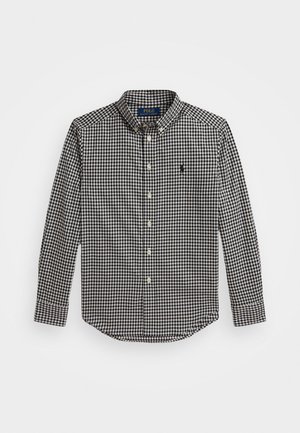 Camisa de botão em preto e branco com padrão quadrado, mangas longas, colarinho, bainha arredondada e um pequeno logótipo no lado esquerdo. Material em algodão.