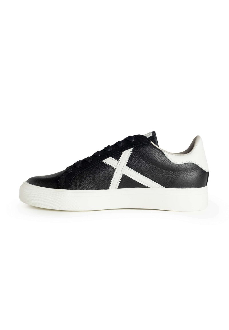 Sneaker in pelle nera con suola in gomma bianca e un distintivo design a croce bianca sul lato. Superficie testurizzata, forma della punta rotonda.