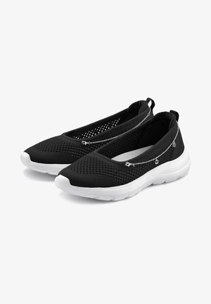 Zapatos negros de malla sin cordones con una superficie texturizada, suela de goma blanca y acentos decorativos de cadena plateada en la parte superior.