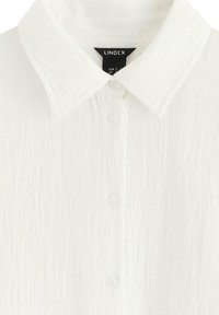 Camisa blanca de botón texturizada con cuello clásico y botones transparentes. La etiqueta indica "Lindex," tamaño EUR S, UK.